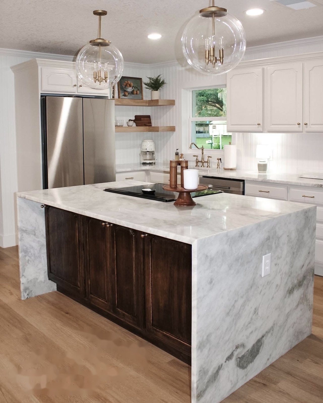 Kitchen remodel in Lakeland, FL with waterfall marble island, globe pendants, and refreshed dark cabinets
